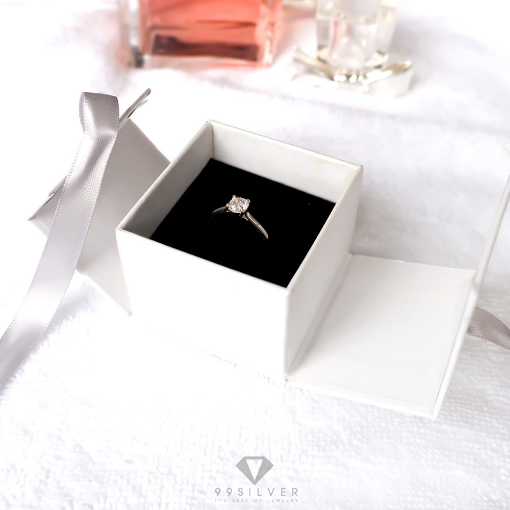 กล่องใส่แหวนสีขาวสี่เหลี่ยม  มีริบบิ้นผูกโบว์สำหรับยึดฝา ข้างในบุด้วยสปั้นช์นิ่มสีดำ