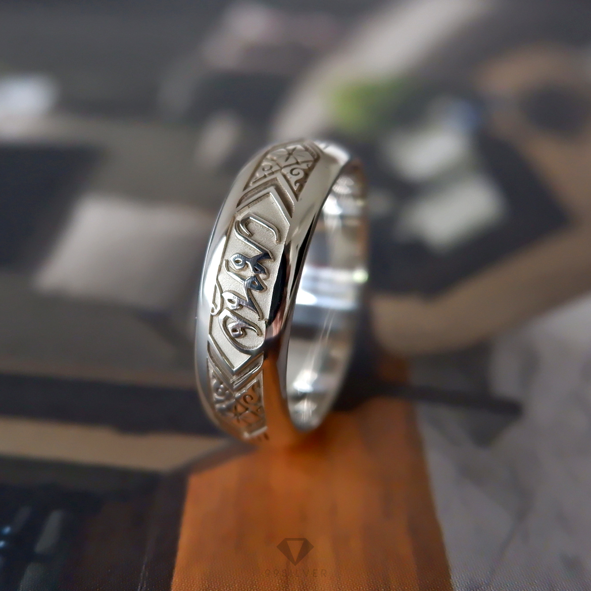 แหวนนามสกุลเงินแท้หน้ากว้าง 6 มิลลิเมตร ผิวโค้ง พื้นหลังพ่นทราย พร้อมแกะลายไทย